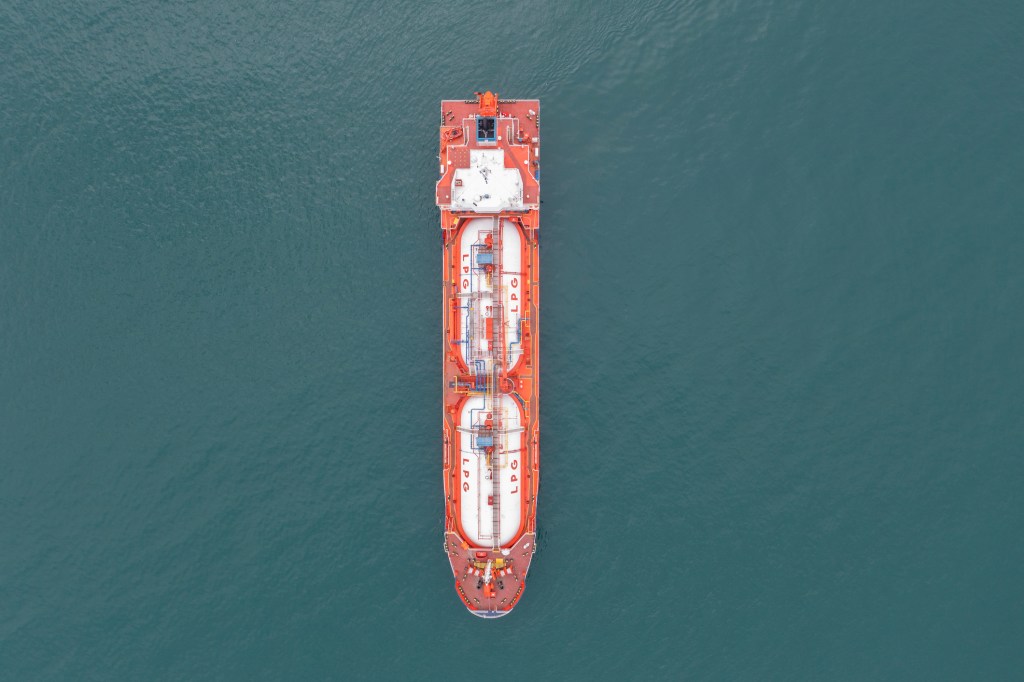 Aerial view of a tanker ship traveling over open ocean in a clear day.