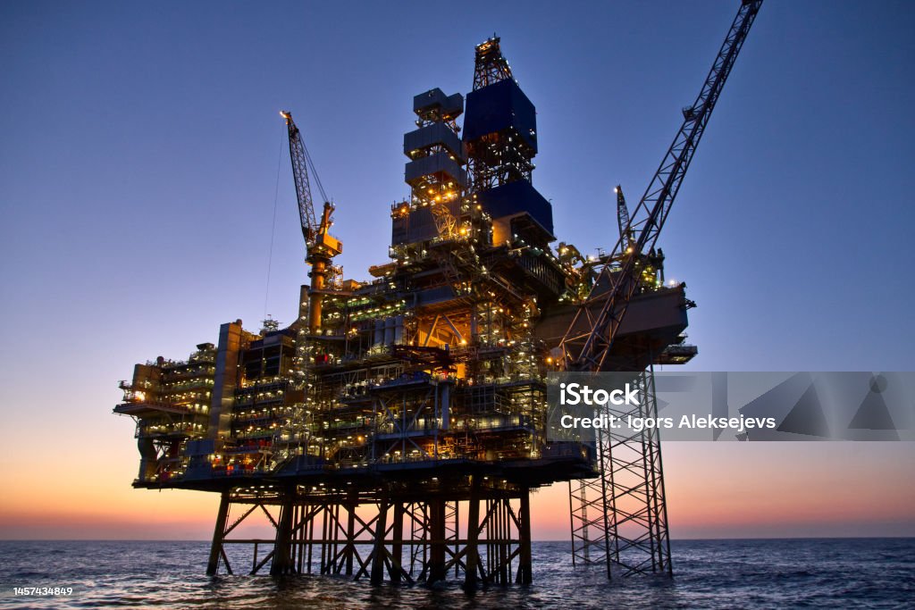 Offshore oil and gas platform in the sea at sunset. 
Jack up rig crude oil production in ocean.