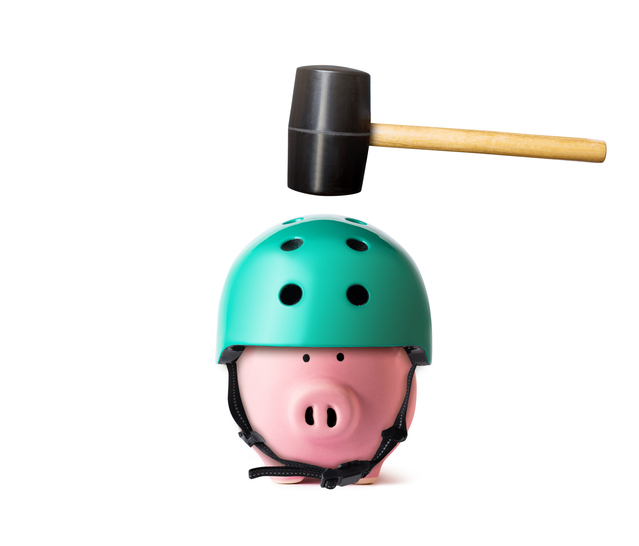 Piggy bank in a helmet with hammer